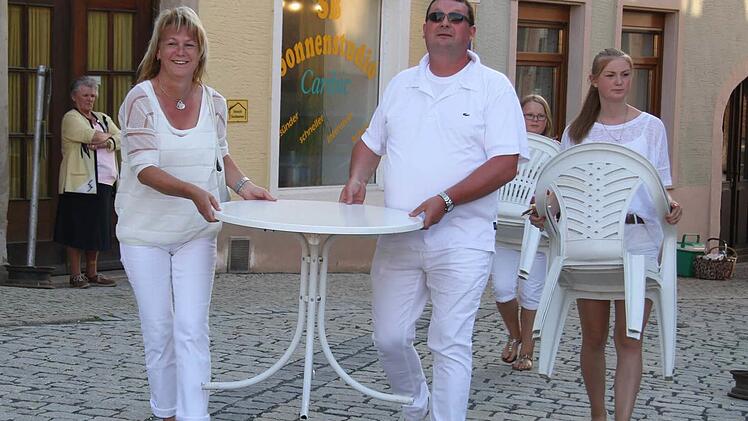 Je später der Abend, desto fröhlicher die Gäste: Auch Klaus und Michaela Witzgall schleppten - gemeinsam mit Tochter Melina- Tische und Bänke auf den Marktplatz. Foto: Sonja Adam