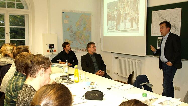 Bürgermeister Jens Korn (re) gibt den 28 jungen Damen und Herren der Hochschule Coburg einen Überblick über die Historie und die Traditionen in Wallenfels. Sitzend daneben Bürgermeister Gerhard Wunder und Professor Mario Tvrtkovic