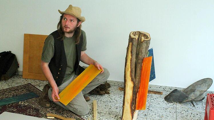 Johannes Haußner, Kunstschaffender und Maler, entwirft eine Lampe aus Holz und Plastik.