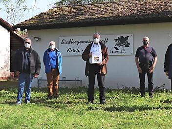 Vor dem Siedlerheim treffen sich die Vereinsvertreter (von links): Otto Hörner, Kaspars Paegle, Rainer Diehl, Franz Rist, Anton Kohling mit Chronik, Vorsitzender Uwe Kanscheit, Rupert Mayer, Bertram Batz.