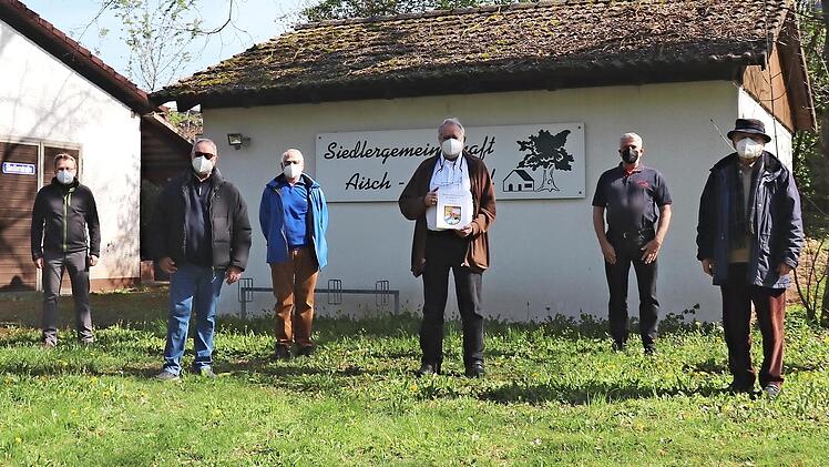 Vor dem Siedlerheim treffen sich die Vereinsvertreter (von links): Otto Hörner, Kaspars Paegle, Rainer Diehl, Franz Rist, Anton Kohling mit Chronik, Vorsitzender Uwe Kanscheit, Rupert Mayer, Bertram Batz.