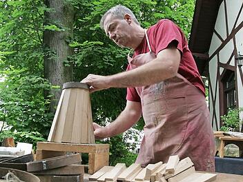 Büttner Anton Hofmann greift sich eine vorbereitete Daube , versieht eine Seite mit Leim und passt diese an die anderen Dauben an.  Fotos: Sylvia Hubele