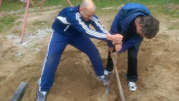 Trainer Bastian Bauer (links) und Platzwart Ulrich Steiner mühten sich ordentlich, um die alten Halterungen aus dem Boden zu graben. Foto: Patricia Pluta