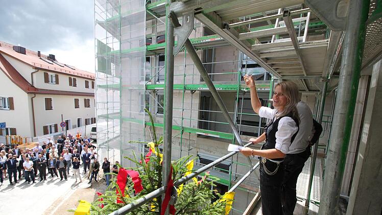 "Steh'n hier gerichtet die Gebäude, zu unserer allergrößten Freude", sagt Zimmerermeisterin Katrin Eisenhuth bei ihrem Richtspruch und hebt das Glas.  Foto: Andreas Oswald