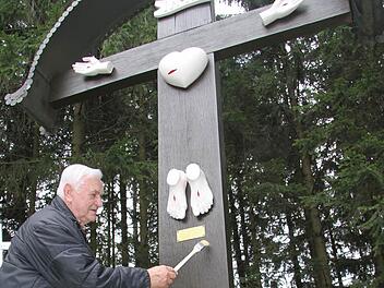 Der Wartenfelser Ludwig Melzer hat seit zwölf Jahren eine Art Patenschaft für das Fünf-Wunden-Kreuz mitten im Wald übernommen. Jetzt hat er es neu gestrichen, denn am Karfreitag spricht Pater Godfryd dort die Sieben Worte Jesu. Foto: Sonja Adam
