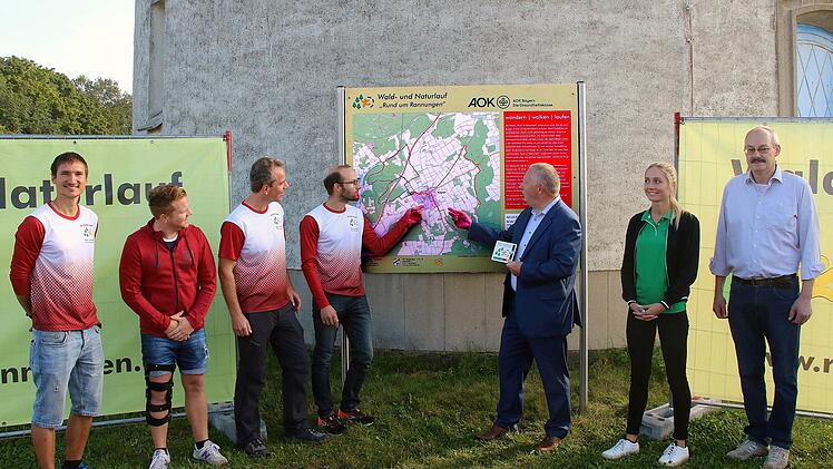 Der Abteilungsleiter der TSV-Laufgruppe Markus Veth, der  Sport-Vorstand des TSV Tobias Hüllmantel, die Organisatoren des Laufs  Stefan Bretscher und Tobias Werner, Landrat Thomas Bold, AOK-Vertreterin  Franziska Markert und Bürgermeister Fridolin Zehner vor einem der  neuen Schilder.