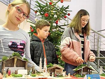 Johanna (von links), Lukas und Nora, die ihre Schwester Vera vertrat, platzierten ihre Krippen in der Sparkasse.  Foto: Waltraud Enkert