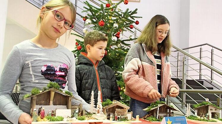 Johanna (von links), Lukas und Nora, die ihre Schwester Vera vertrat, platzierten ihre Krippen in der Sparkasse.  Foto: Waltraud Enkert