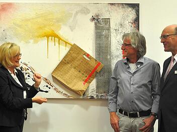 Vernissage in der Bank Schilling: Kulturmanagerin Astrid Hedrich-Scherpf, Künstler Helmuth Marx und Vorstand Matthias Busch (von links) vor dem dreidimensionalen "Hugo Boss Bild", eine sogenannte Assemblage. Foto: Jacqueline Vera Mihm