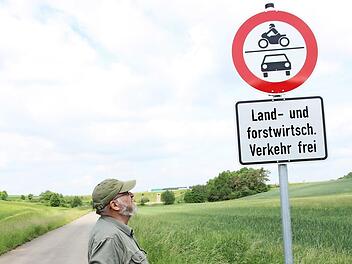 Reinhard Landgraf schaut steht vor einem der neuen Verkehrsschilder bei Rottershausen, die Auto- und Motorradfahrer davon abhalten sollen, Flurwege zu benutzen. Foto: Heike Beudert