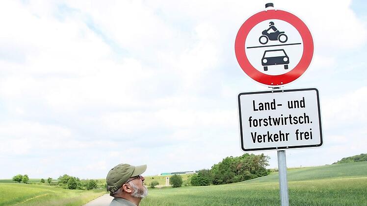 Reinhard Landgraf schaut steht vor einem der neuen Verkehrsschilder bei Rottershausen, die Auto- und Motorradfahrer davon abhalten sollen, Flurwege zu benutzen. Foto: Heike Beudert