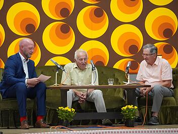 Moderator Alexander Pf&uuml;lb (von links) hat sich von Erich Metz (Stangenroth) und Georg Rottenberger (Wollbach) erz&auml;hlen lassen, wie gro&szlig; der Widerstand in Stangenroth gegen den Zusammenschluss damals war - passend vor der 70er-Jahre-Tapete.