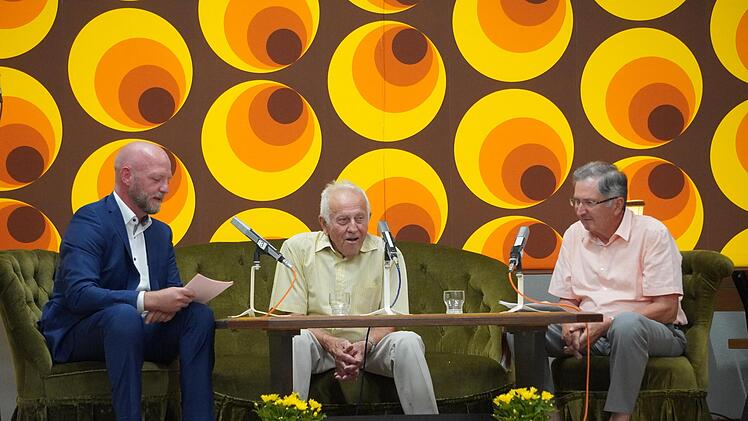 Moderator Alexander Pf&uuml;lb (von links) hat sich von Erich Metz (Stangenroth) und Georg Rottenberger (Wollbach) erz&auml;hlen lassen, wie gro&szlig; der Widerstand in Stangenroth gegen den Zusammenschluss damals war - passend vor der 70er-Jahre-Tapete.