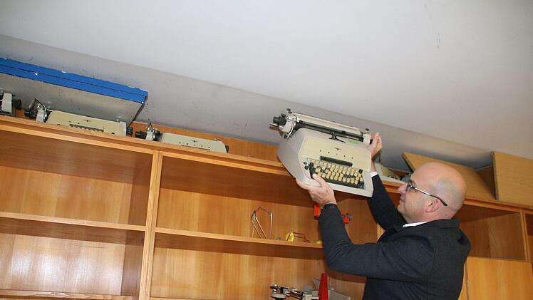 Michael Kastl holt eine der Schreibmaschinen aus ihren Versteck, in dem sie wohl 35 Jahre gelagert hatten. Foto: Thomas Malz