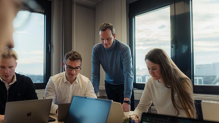 Florian Neuhann (zweiter von rechts) schaut Jurastudenten beim Experiment "Mensch gegen Maschine" zu. Ist die menschliche Intelligenz noch durchsetzungsf&auml;hig bei juristischen Fragestellungen - oder hat die KI schon jetzt die Nase vorn?