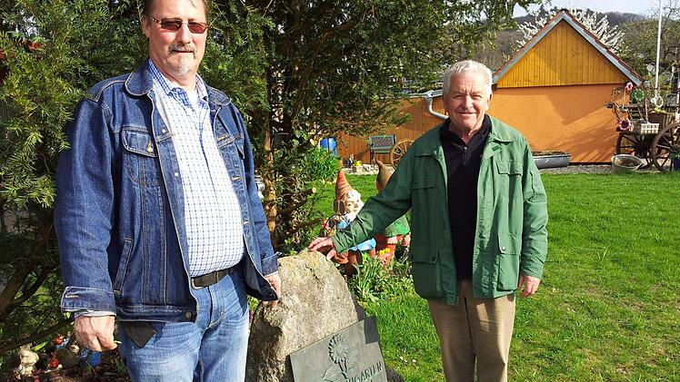 Richard Götz und Siegfried Seyfried neben dem Gedenkstein an Kolonie-Gründer Hugo Post.  Foto: Andreas Schmitt