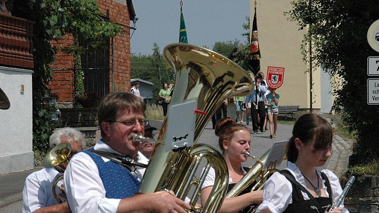 Mit Musik und Fahnen schlängelte sich der Umzug durch die Straßen von Rothhausen. Foto: Daniel Wiener