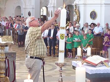 Wallfahrtsführer Bernhard Steger entzündete die Jubiläumskerze in der Basilika Gößweinstein. Foto: Thomas Weichert