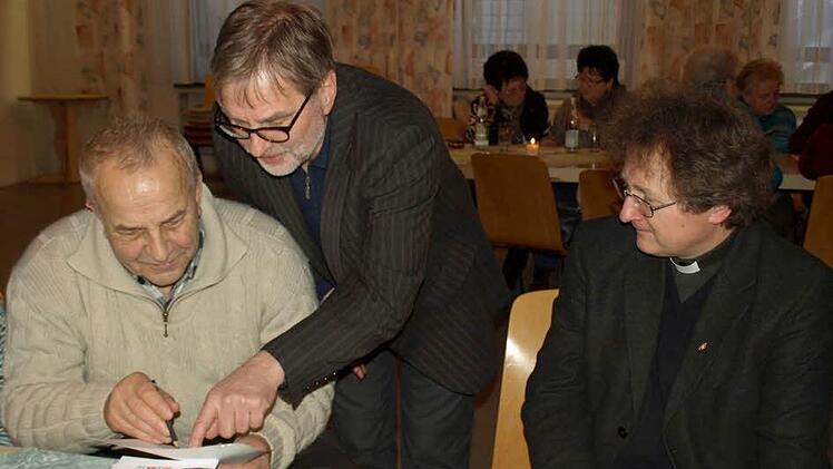 Pater Jan Poja (rechts) beobachtet genau, wie Hans Müller-Zeiner (links) zusammen mit Norbert Grundhöfer die Aufgaben des Gehirnjoggings studiert.