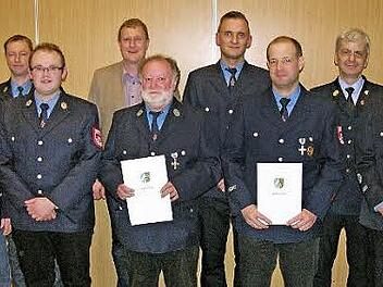 Feuerwehr-Führungskräfte, Vorstandsmitglieder und Ehrengäste flankieren die Jubilare Franz Scheckenbach und Stefan Pechtold (mit Ehrenurkunden).  Foto: Klaus Oelzner