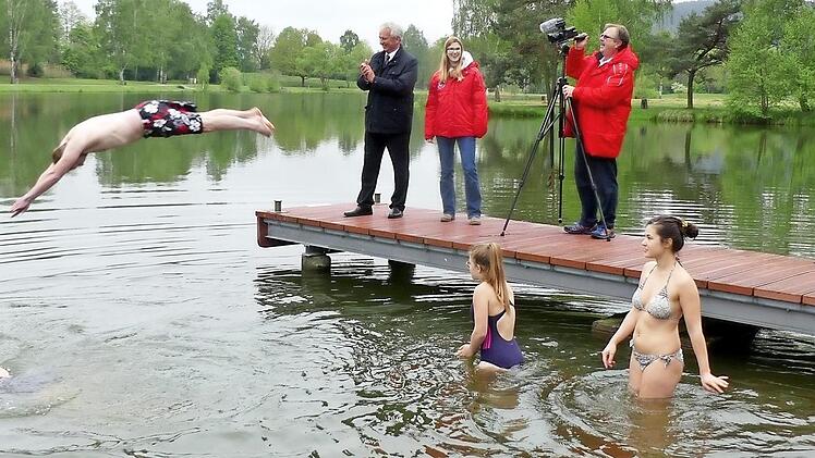 Gemeinderat Christian Potzel mit einem kühnen Sprung und (vorne, von links) Gerlinde Muhr, Ronja Thiel, Johanna Surowi und Tim Leppert wagten sich beim Anschwimmen der Wasserwacht in den kühlen Badesee. Aufmerksame Zuschauer waren Bürgermeister Werner Diersch, Wasserwacht-Vorsitzende Nadine Kolb und Zweiter Bürgermeister Albert Kolb. Foto: Dieter Hübner