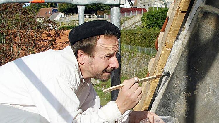 Steinmetz   Horst Wittstadt bearbeitet mit dem Pinsel die Fassade des Sudhauses. Im Hintergrund ist das Schloss zu sehen.   Foto: Alexander  Hartmann