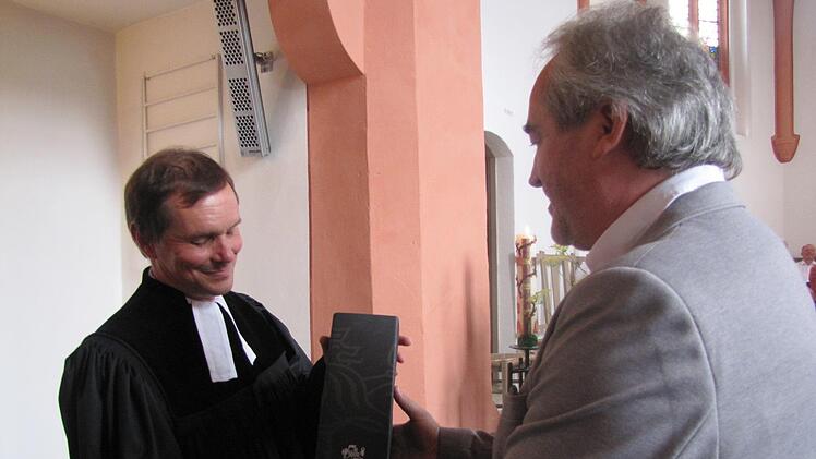 Dietmar Wächter, Ortssprecher und Bürgervereinsvorsitzender in Lützelbuch, hatte als Wegzehrung Rotwein aus Südtirol für Pfarrer Klaus Göpfert dabei, eine Reverenz der Lützelbucher Freunde aus Gais. Foto: Martin Koch
