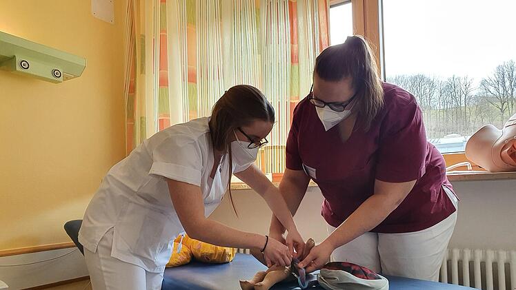 Hebammen-Studentin Luzie Dück übt mit Ausbilderin Franziska Kraus am Modell das Abbinden der Nabelschnur. Foto: Christine Fischer