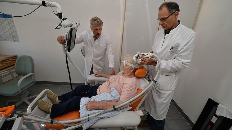Peter Rieckmann (links) und Hermann Weber bei der Behandlung mit der Magnetspule. Sie muss zielgenau auf dem Kopf platziert werden. Foto: Ronald Rinklef