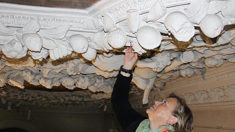Die Architektin Ursula Huber aus Forchheim sucht die Hassenberger Stuckdecke durch Klopfen nach Hohlräumen ab und dokumentiert diese anschließend. Foto: Cindy Dötschel