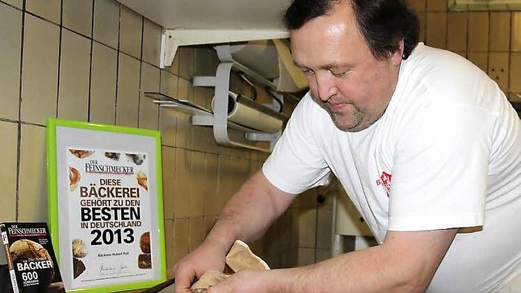 Hubert Ruß beim Backen des Spritzgebäcks. Der Teig wird durch einen Spritzbeutel gedrückt. Foto: Schadeck