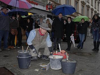 Der Kölner Bildhauer Gunter Demnig beim Verlegen früherer Stolpersteine