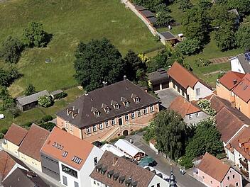 Im Stegauracher Rathaus (vorne Mitte) ist man trotz der hohen Kosten nach wie vor glücklich über den Erwerb des Böttinger Landhauses (das rote Gebäude). Foto: Heinrich Hoffmann/Archiv