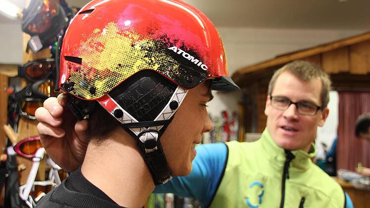 Damit ein Skihelm auch schützt, muss er richtig sitzen: Roland Betz (rechts) hilft bei der Anprobe. Der Inhaber von Rolands Alpin-Laden hat wie seine Kollegen anderer Sportfachgeschäfte eine erhöhte Nachfrage nach Helmen festgestellt.  Foto: Sebastian Martin