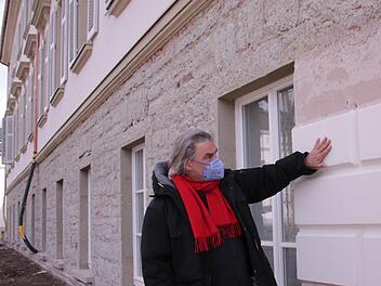 Christian Teichmann prüft die ersten Quader des Bossenputzes, die am Fassadensockel aufgebracht wurden. Foto: Benedikt Borst