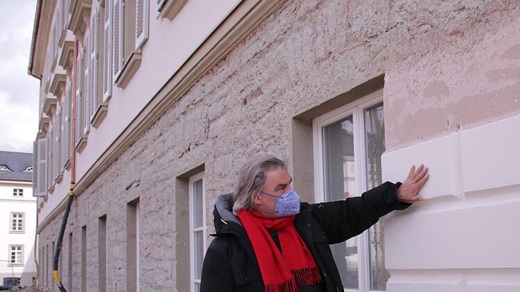 Christian Teichmann prüft die ersten Quader des Bossenputzes, die am Fassadensockel aufgebracht wurden. Foto: Benedikt Borst