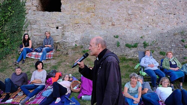 Peter Hub rezitiert vor seinen Zuhörern, die sich auf dem Gelände an der Trimburg niedergelassen haben. Foto: Gerd Schaar