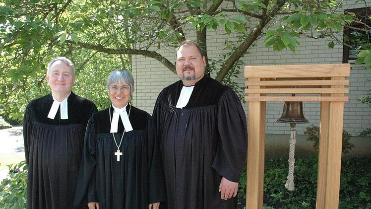 Am Himmelfahrtsgottesdienst läutete die kleine Kirchenglocke die Pfarreigründung in der Katharina-von-Bora-Gemeinde im Heimatring ein. Pfarrer Ralph Utz, Regionalbischöfin Dorothea Greiner und Gemeindepfarrer Detlev Juranek freuten sich über diesen gelungenen Weg. Foto: Edwin Meißinger