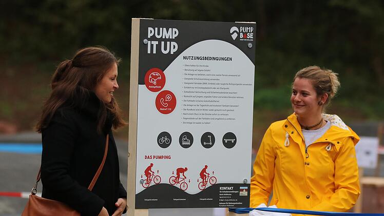 Höhepunkt nach jahrelangen Bemühungen um eine neue Freizeitaktivität für die Wildfleckener Jugend: Katharina Edelmann (links) vom Konversionsmanagement des Landkreises enthüllt eine Schautafel am neuen Pumptrack.Foto Sebastian Schmitt