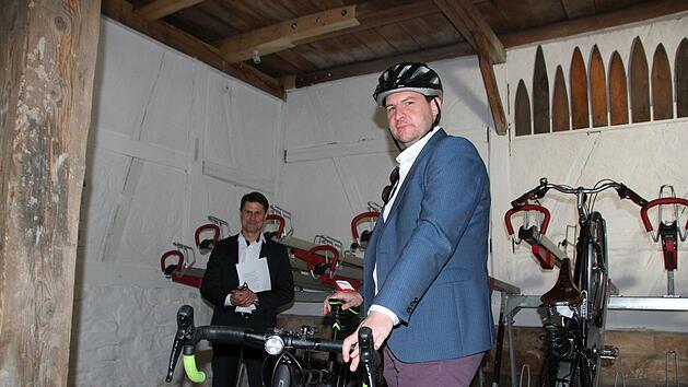 Wohnbau-Geschäftsführer Christian Meyer (links) und OB Dominik Sauerteig in der neuen Fahrradscheune. An der Wand hängen übrigens sogenannte Balkbretter, die noch aus der Zeit stammen, als die Scheune zum Gerben genutzt wurde.