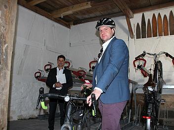 Wohnbau-Geschäftsführer Christian Meyer (links) und OB Dominik Sauerteig in der neuen Fahrradscheune. An der Wand hängen übrigens sogenannte Balkbretter, die noch aus der Zeit stammen, als die Scheune zum Gerben genutzt wurde.