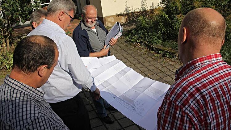 Den Bauplan der Lebens- und Arbeitsgemeinschaft Sonnenhof studieren vor Ort in Obermerzbach (von links): Gemeinderat Gerald Karl, Bürgermeister Helmut Dietz, Gemeinderat Robert Bohla (verdeckt), Geschäftsleiter Edgar Maier und Gemeinderat Jürgen Fromm. Foto: Helmut Will