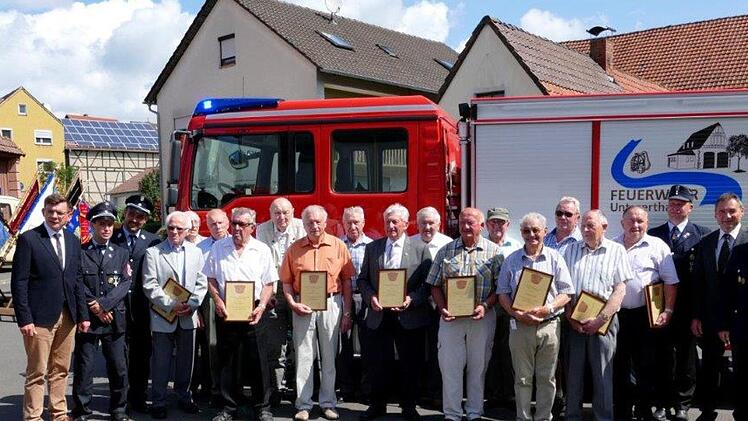 Den Veteranen der Untererthaler Feuerwehr dankten Bürgermeister Armin Warmuth (links) und die heimische Feuerwehrführung mit einer Urkunde und einem Weinpräsent.                 Foto: Josef Rauschmann