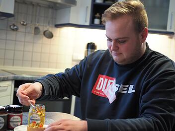 Robin Stüllein bereitet sich ein Brot mit dem Chutney "Orientalisch Würzig", das sein Start-up Bacuma herstellt, zu. Enthalten sind Zucchini, Paprika und Zwiebeln.