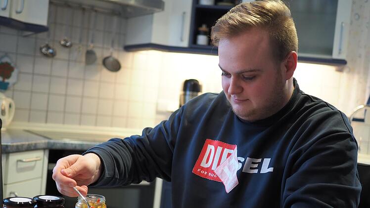 Robin Stüllein bereitet sich ein Brot mit dem Chutney "Orientalisch Würzig", das sein Start-up Bacuma herstellt, zu. Enthalten sind Zucchini, Paprika und Zwiebeln.