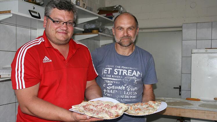 Matthias Gößwein (rotes Shirt) und Thomas Amon verarbeiten während des Weinfestes insgesamt 16 Kilogramm Teig zu ungefähr 90 bis 100 Flammkuchen.  Foto: Sylvia Hubele