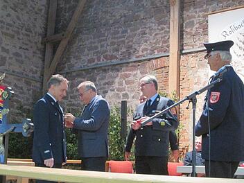 Rudi Leuber erhält die Ehrennadel von Emil Müller angesteckt, rechts daneben Kreisbrandinspektor Marco Brust. Foto: Diana Leitsch