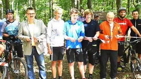 Wie bei einer Straßenfreigabe wurde die Mountainbikestrecke bei Goßmannsdorf frei gegeben. Von links an der Schere Bürgermeister Bernd Fischer (Riedbach), Philipp Behnke, Jakob Guschker, Paul Guschker, Hofheims Bürgermeister Wolfgang Borst und rechts Jagdpächter Klaus Scheuring.  Foto: Gerhard Schmidt