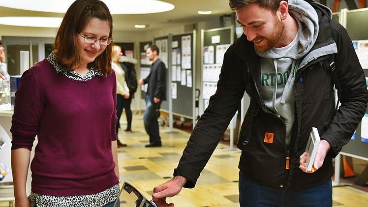 Die Firmen hatten Anschauungsmaterial dabei, zum Beispiel eine Bedienungsanleitung für hochwertige Autos, von links Praktikantin Juliana Kocher und Student Matthias Wilz. Foto: Gabi Arnold