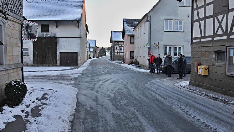 Die Sicht wird von der Einmündung, wo die Mitglieder des Bauausschusses stehen, nach links in Richtung Untermerzbach durch den Verkehrsspiegel (oben links) deutlich verbessert und das Einfahren in die Vorfahrtsstraße somit erleichtert. Foto: Helmut Will